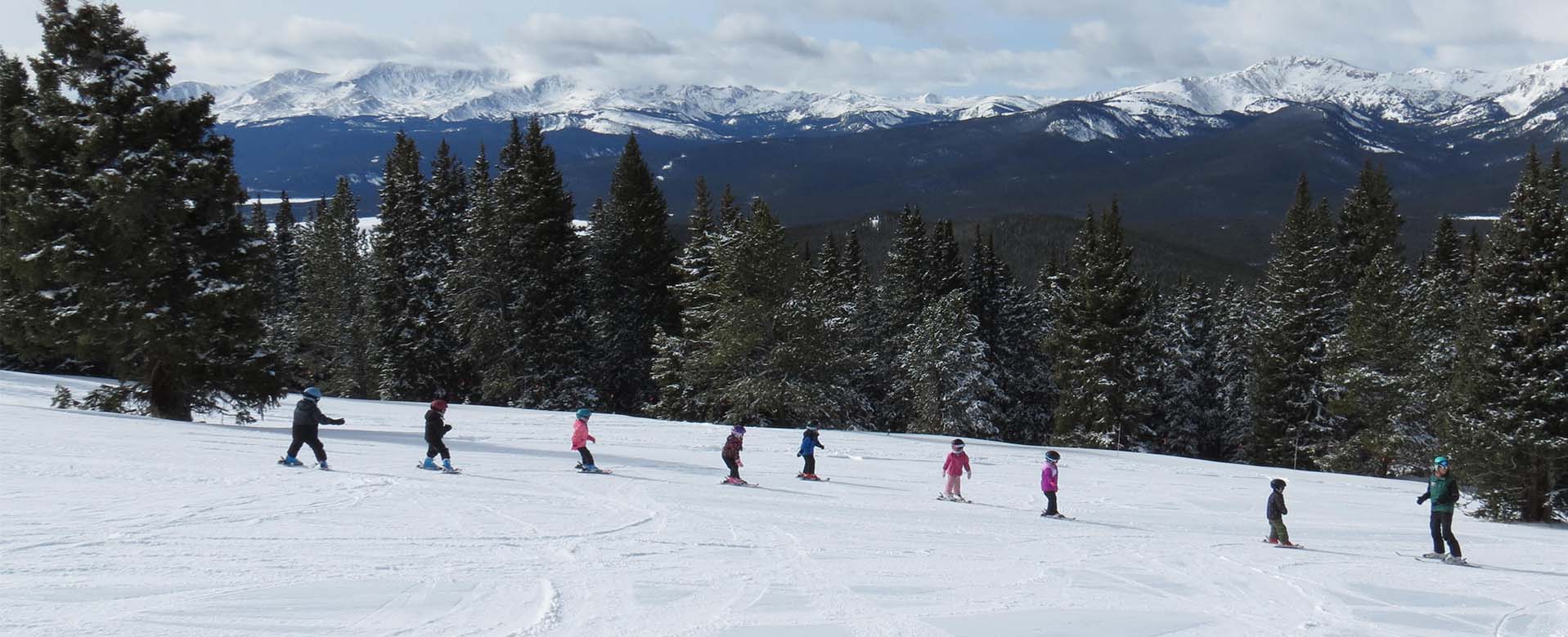 young skiers skiing down the slope in a line