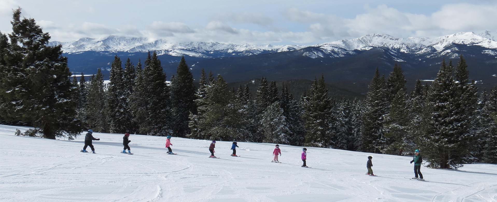 young skiers skiing in a line down the slopes