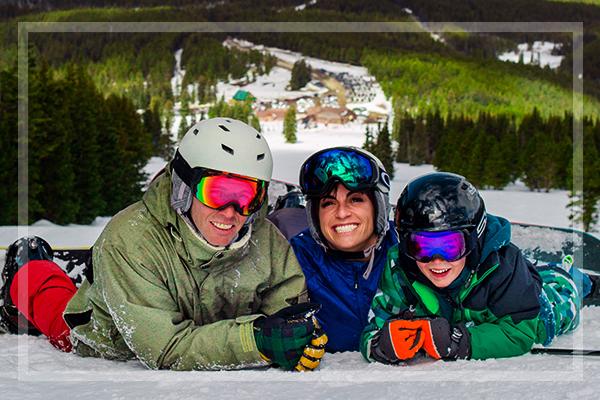 family laying on the ski slope