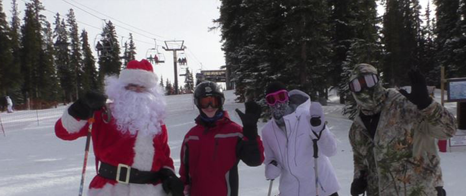 Santa posing for a picture with skiers